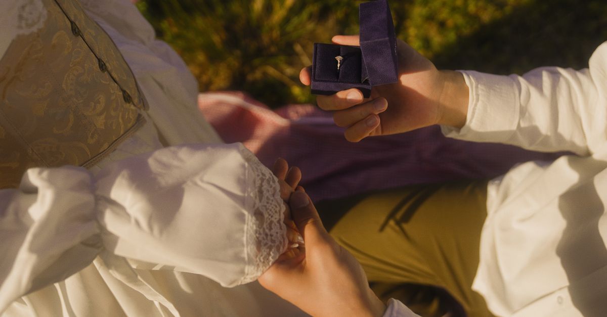 Vintage-inspired outdoor proposal with engagement ring and romantic atmosphere.
